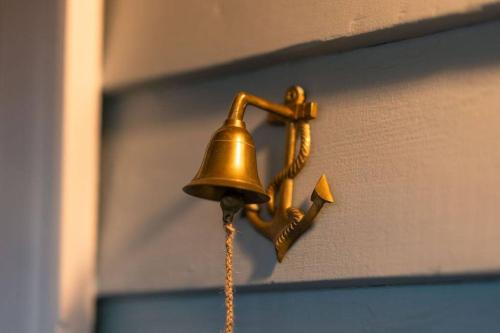 a bell hanging on a door with a chain at Signal Cottage close to beach and Semaphore Road in Semaphore