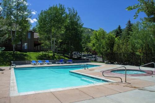 a large swimming pool with blue chairs at Ski In and Out, Canyons Village Hidden Creek, Private Hot Tub in Park City