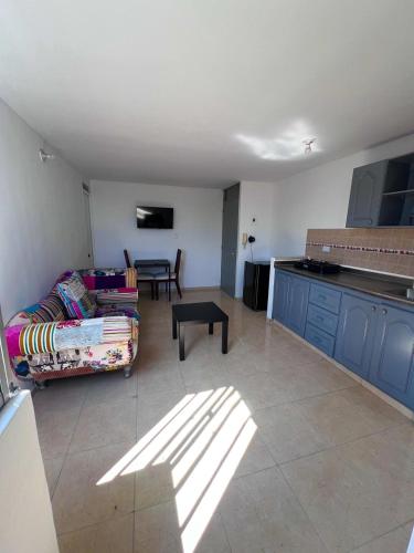 a living room with a couch and a kitchen at Edificio Las Vegas Apto privado a 15 min de Clínica Valle del Lili y Univalle a 5 min de Unicentro in Cali