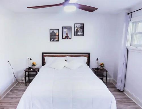 a bedroom with a white bed with a ceiling fan at Private Suite near Busch Gardens Adventure Island USF and I-275 in Tampa