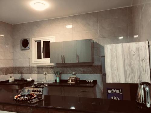 Una cocina con gabinetes blancos y una encimera negra. en Diamond Guest House K, en Asuán