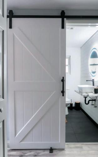 a sliding barn door in a bathroom with a sink at Private Suite near Busch Gardens Adventure Island USF and I-275 in Tampa