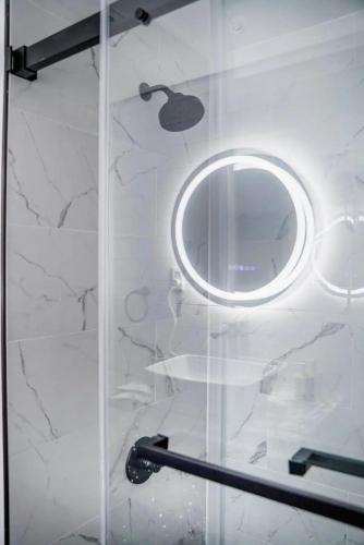 a shower with a round mirror on a wall at Private Suite near Busch Gardens Adventure Island USF and I-275 in Tampa