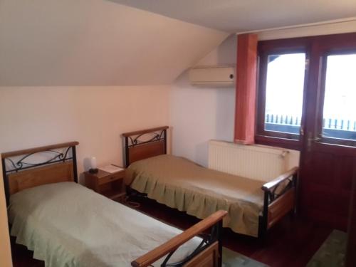 um quarto com duas camas e uma janela em Pensiunea Doina & Jenő em Târgu-Mureş