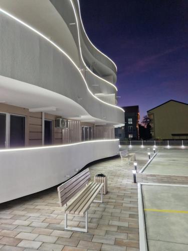 a row of benches sitting on the side of a building at Apartman Kali Srebrno jezero in Ostrovo
