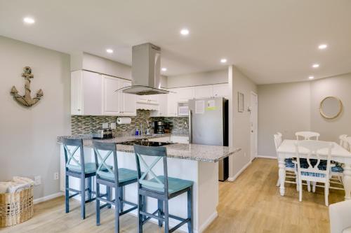 a kitchen with white cabinets and blue bar stools at Emerald Isle Condo with Indoor Pool and Beach Access! in Emerald Isle
