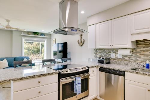 a kitchen with white cabinets and a stove top oven at Emerald Isle Condo with Indoor Pool and Beach Access! in Emerald Isle