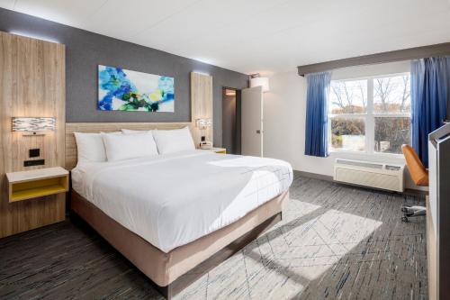 a hotel room with a large bed and a window at La Quinta by Wyndham Lexington Park - Patuxent in California