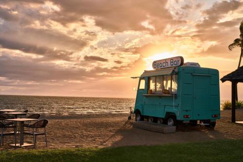 a green food truck parked on the beach at Sheraton Fiji Golf & Beach Resort in Denarau