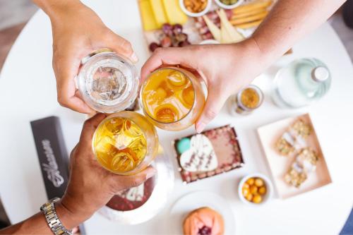 two people holding up glasses of drinks over a table at Sheraton Fiji Golf & Beach Resort in Denarau
