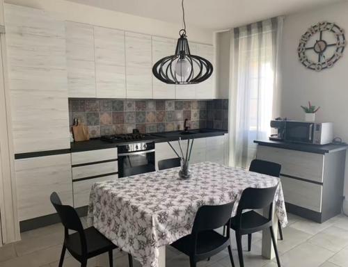 una cucina con tavolo e sedie e una cucina con piano cottura di La casa di Ely a Viareggio