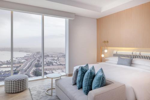 a bedroom with a large bed and large windows at Four Points by Sheraton Jeddah Corniche in Jeddah