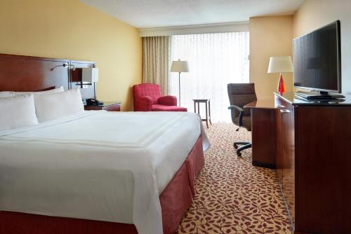 a hotel room with a bed and a flat screen tv at Wyndham Cleveland Airport in Cleveland