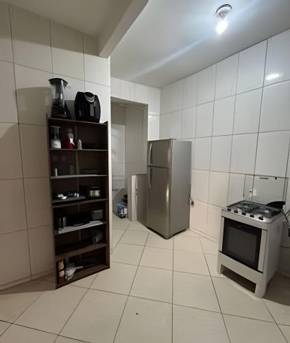 a small kitchen with a refrigerator and a stove at Casa com 2 quartos perto do Buritis in Belo Horizonte