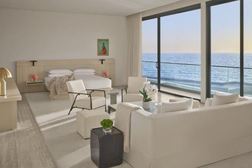 a white living room with a view of the ocean at The Jeddah EDITION in Jeddah