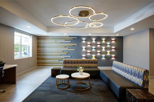 a lobby with a couch and a chandelier at La Quinta by Wyndham Lexington Park - Patuxent in California