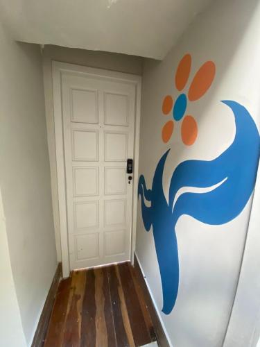 a hallway with a door with a painting on the wall at Prado Premium Lofts e Kitnets com Ar-Condicionado e TV Smart in Belo Horizonte
