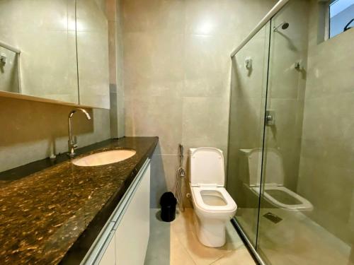 a bathroom with a toilet and a sink and a shower at Prado Premium Lofts e Kitnets com Ar-Condicionado e TV Smart in Belo Horizonte