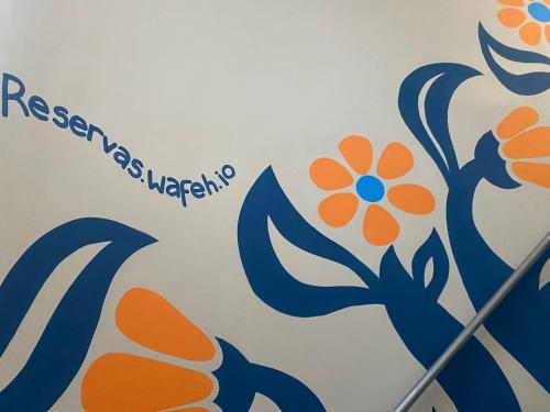 a wall with a sign with a flower on it at Prado Premium Lofts e Kitnets com Ar-Condicionado e TV Smart in Belo Horizonte