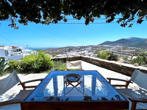 a glass table with a view of a city at Juniper Cycladic House, Serenity Sifnos in Apollonia