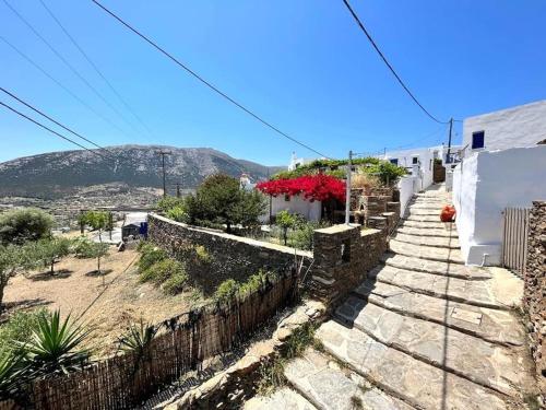 a stone wall with plants and flowers on it at Juniper Cycladic House, Serenity Sifnos in Apollonia