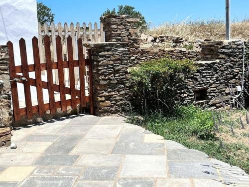 a wooden fence next to a stone wall at Juniper Cycladic House, Serenity Sifnos in Apollonia