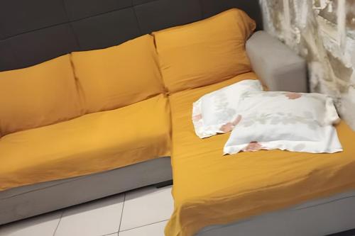 a yellow couch with a pillow on it at Apto no térreo com 2 quartos in Belo Horizonte