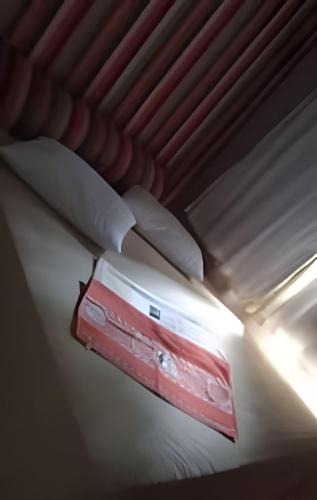 a white bed in a room with a light on it at Apto no térreo com 2 quartos in Belo Horizonte