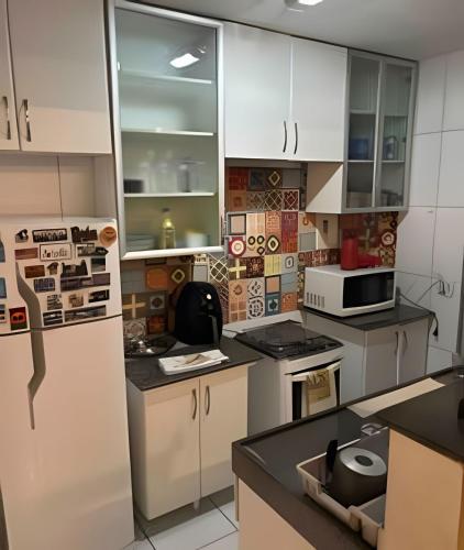 a kitchen with white cabinets and a white refrigerator at Apto no térreo com 2 quartos in Belo Horizonte