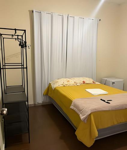 a bedroom with a yellow bed and a window at Casa 5 quartos entre Centro e Pampulha in Belo Horizonte
