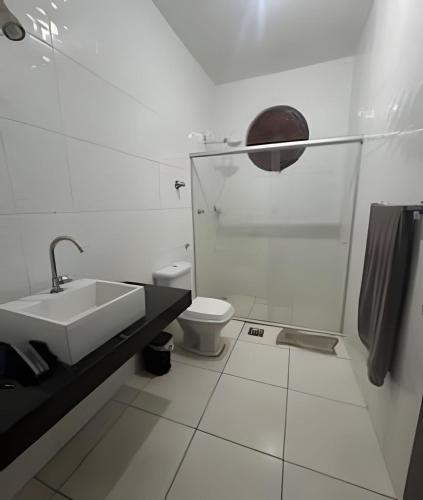 a white bathroom with a sink and a toilet at Casa 5 quartos entre Centro e Pampulha in Belo Horizonte
