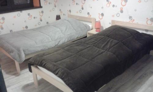 a bedroom with two beds and a wall with circles at La Calougeotte Jeanne in Saint-Jean-du-Marché