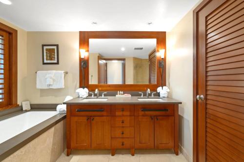 a bathroom with a tub and a sink and a mirror at KBM Resorts FREE CAR Beach Villas at Ko Olina BVK-O-1604 Penthouse Ocean Views in Kapolei