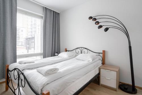 a bedroom with a bed and a large window at Modern 1BR Apartment in Kaleva next to Tram Line in Tampere