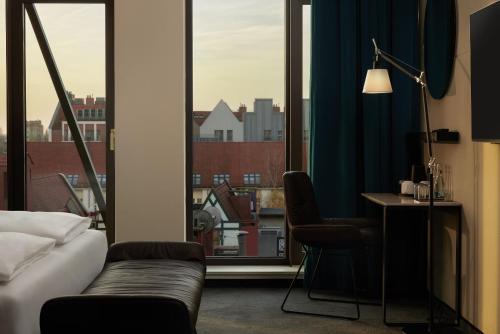 a room with a couch and a desk and a window at The Cloud One Gdansk in Gdańsk