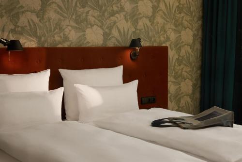 a bedroom with a bed with white pillows and a headboard at The Cloud One Gdansk in Gdańsk