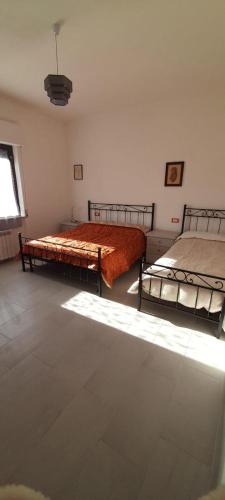 a bedroom with two beds and a window at La Poltrona del Diavolo in Montenero