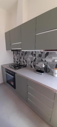 a kitchen with a stove and white cabinets at La Poltrona del Diavolo in Montenero