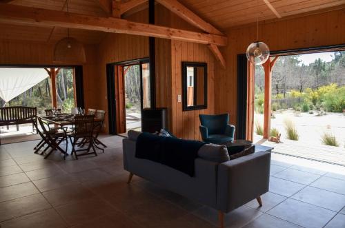 un salon avec un canapé et une table dans l'établissement Maison en Bois 6 pers - Plage&Forêt Montalivet Vensac-Océan, à Vensac