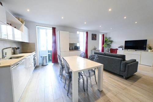 Una cocina y una sala de estar con una mesa y un sofá. en Loft place Masséna avec terrasse, en Niza