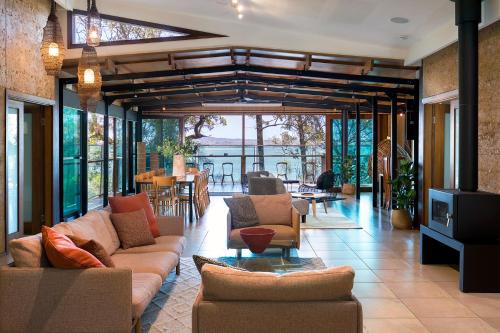 a large living room with couches and a tv at Eumarella Shores Noosa Lake Retreat in Noosaville