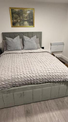 a bedroom with a large bed with a painting on the wall at Irtaza charming suite in Waterlooville