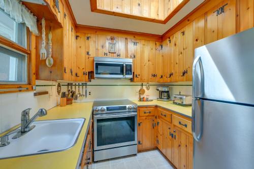 a kitchen with wooden cabinets and a stainless steel refrigerator at Walk to Beach Long Island Wine Country Home! in Cutchogue