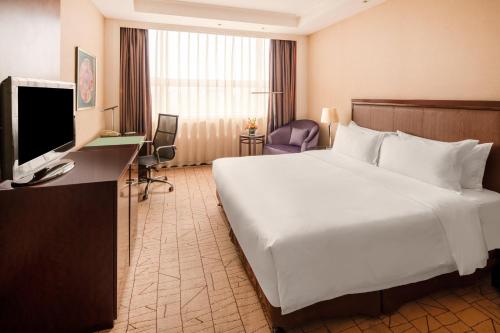 a hotel room with a large bed and a television at Holiday Inn Zhengzhou Zhongzhou by IHG in Zhengzhou