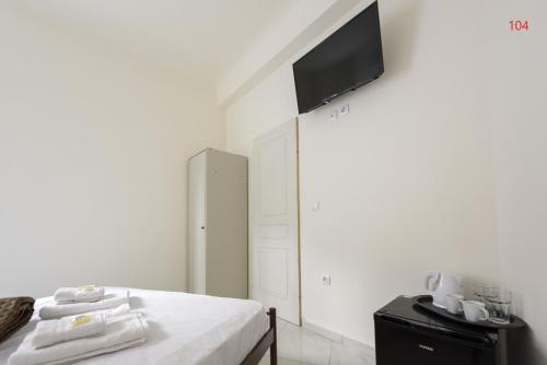 a bedroom with a bed with a tv on the wall at ATHENS COMMERCIAL in Athens