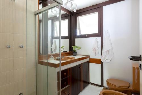 a bathroom with a sink and a shower and a toilet at Casa na Marina com piscina churrasqueira e píer in Guarujá