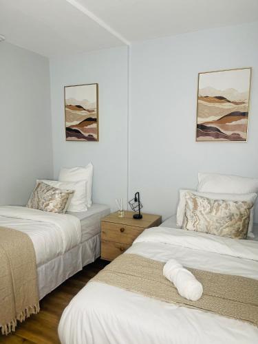 two beds in a room with white walls at Windhoek Cozy stay in Windhoek