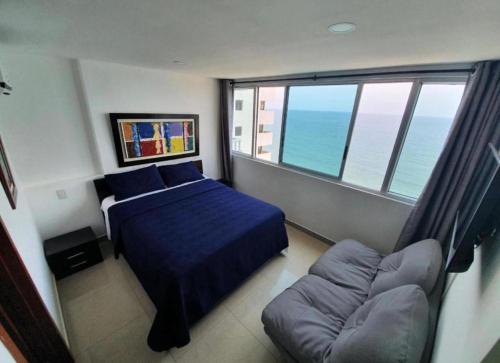a bedroom with a bed and a couch and a window at Luxury Apartments Beachview in Cartagena de Indias