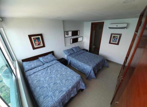 a bedroom with two beds and a window at Luxury Apartments Beachview in Cartagena de Indias