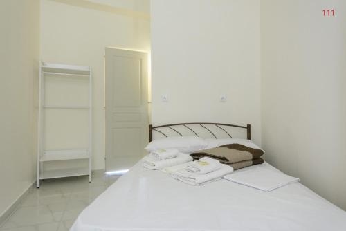 a bedroom with a white bed with towels on it at ATHENS COMMERCIAL in Athens